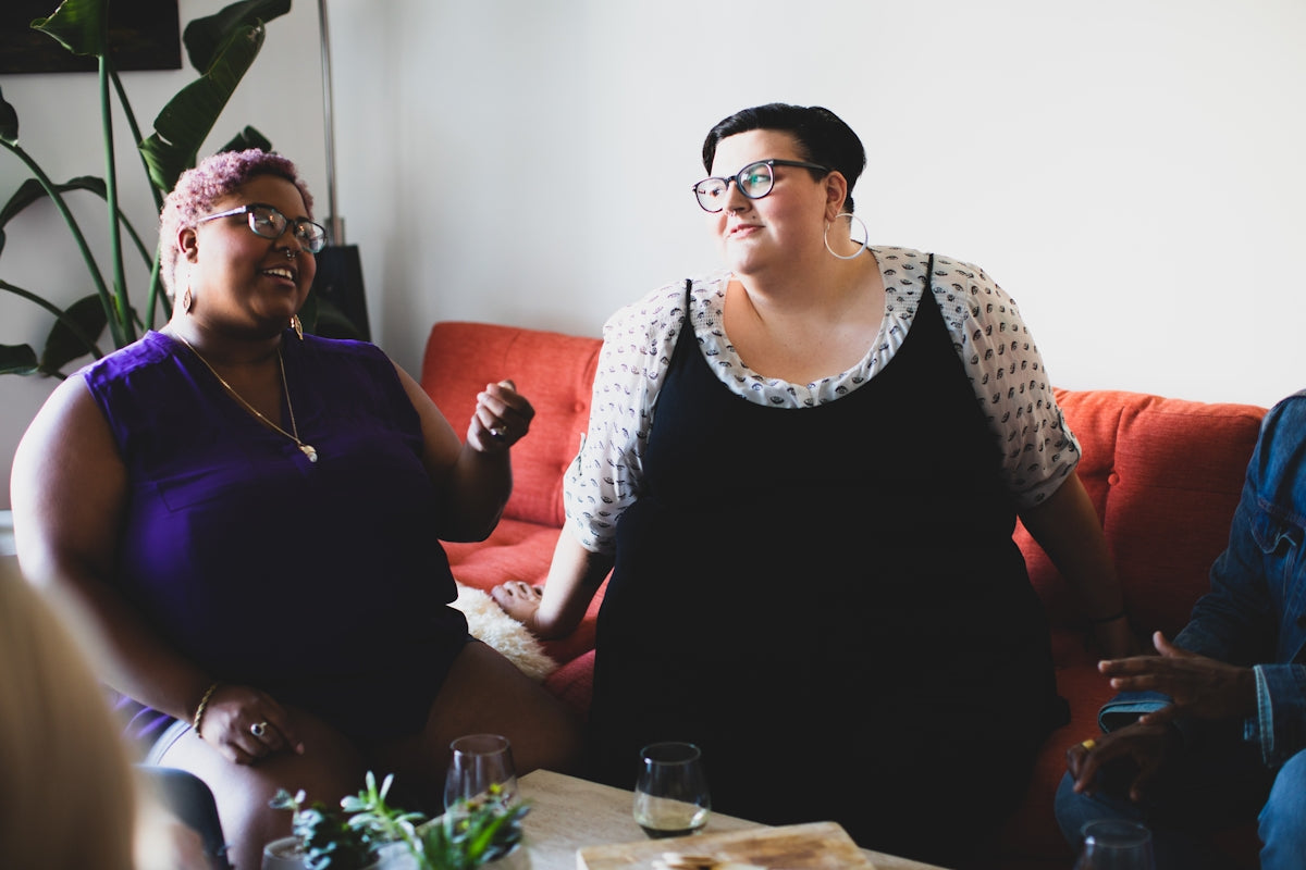 two women sitting on sofa looking at each other