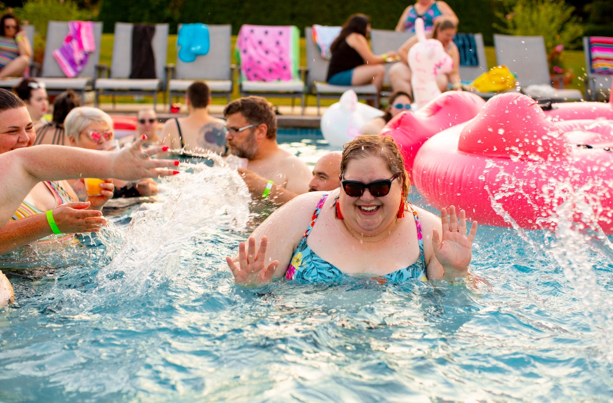 people swimming in the pool with floaters