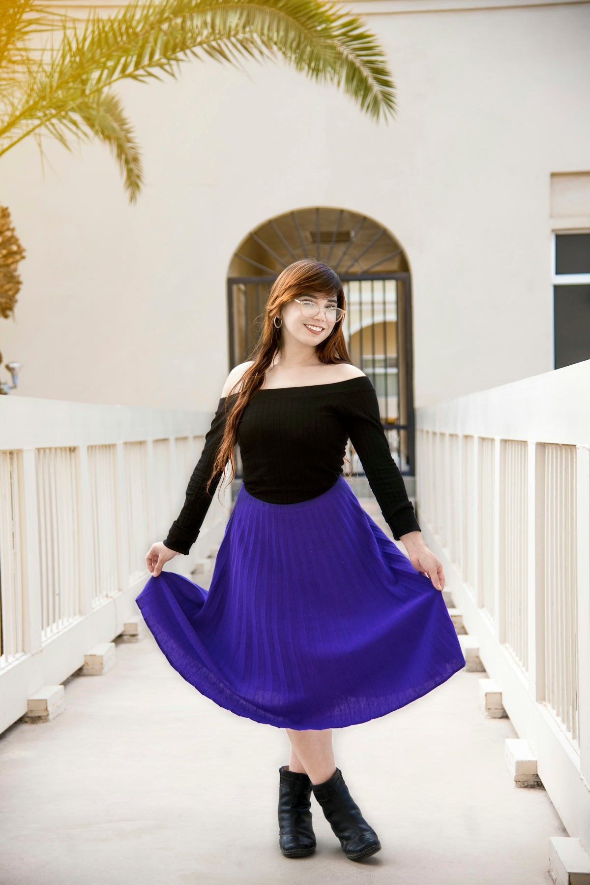 a woman in a black top and a purple skirt