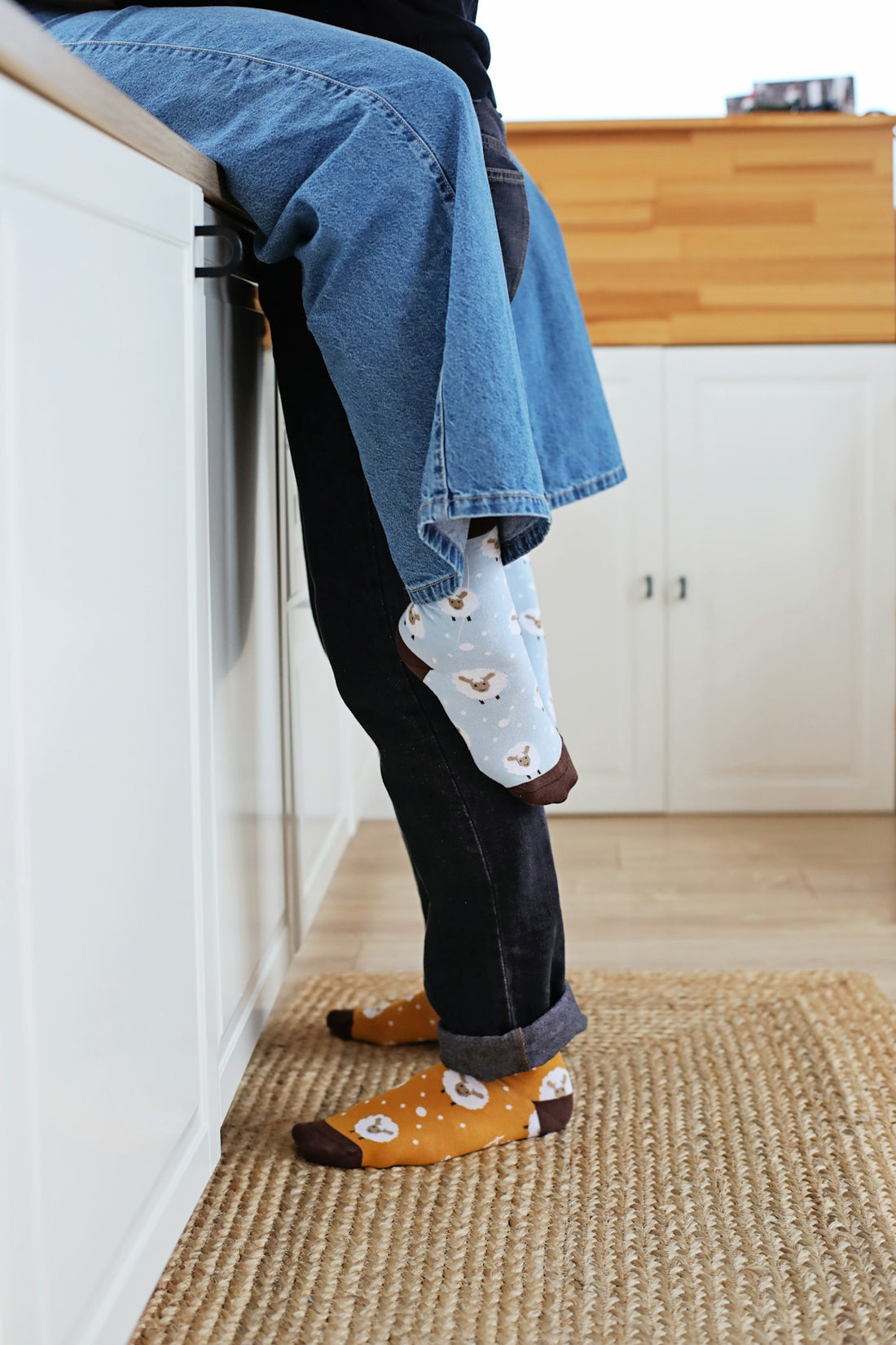 a person sitting on a kitchen counter with their feet on the counter