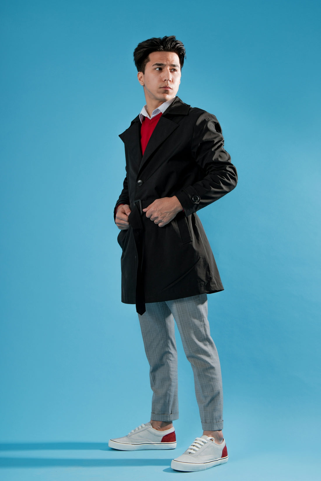 a man in a black coat is posing for a picture