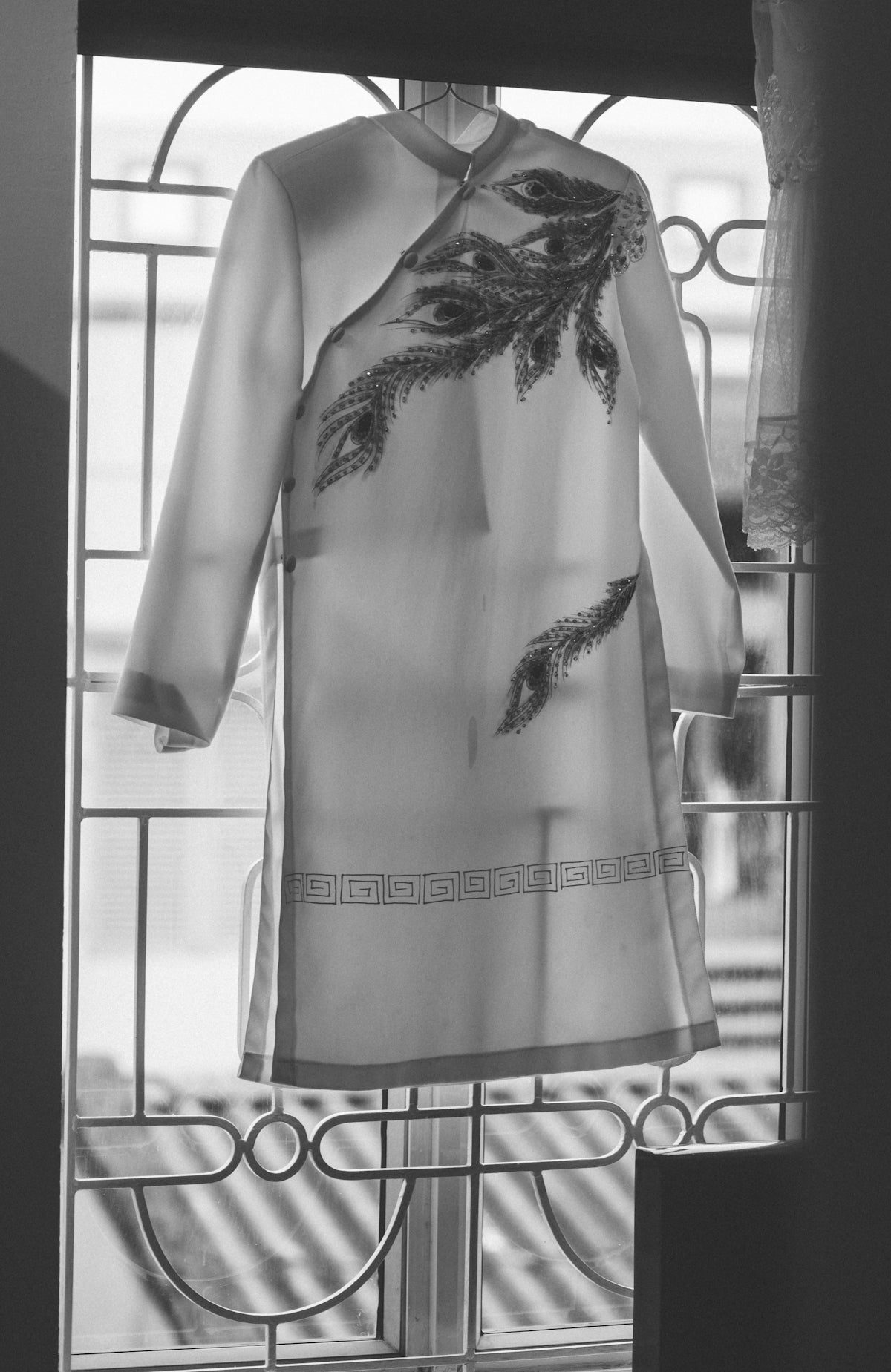 a black and white photo of a dress on a window sill