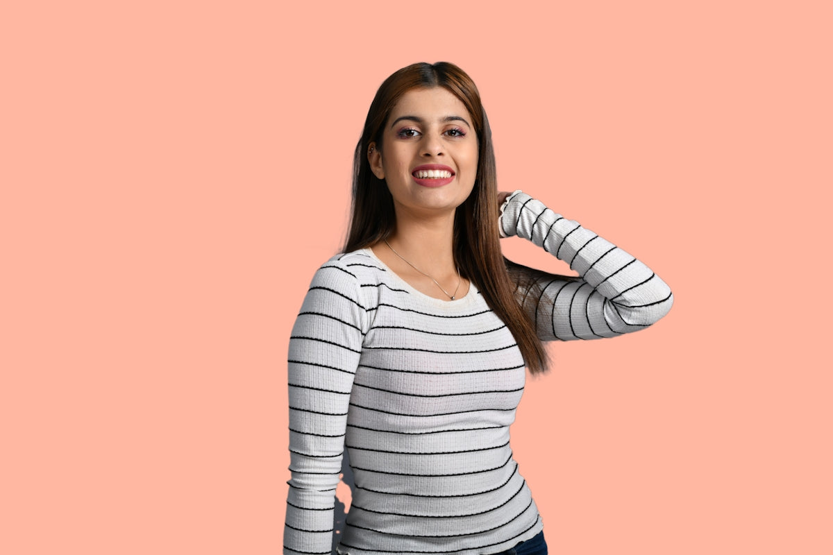 a woman smiling with a pink background