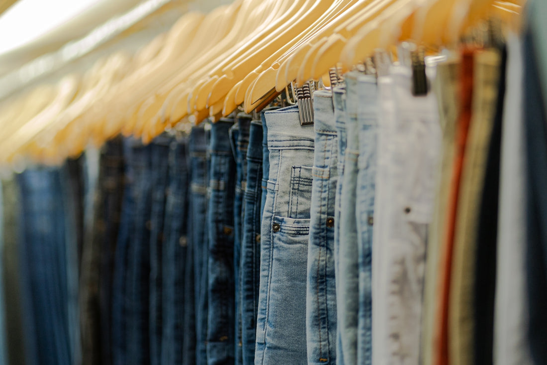 a row of jeans hanging on a rack