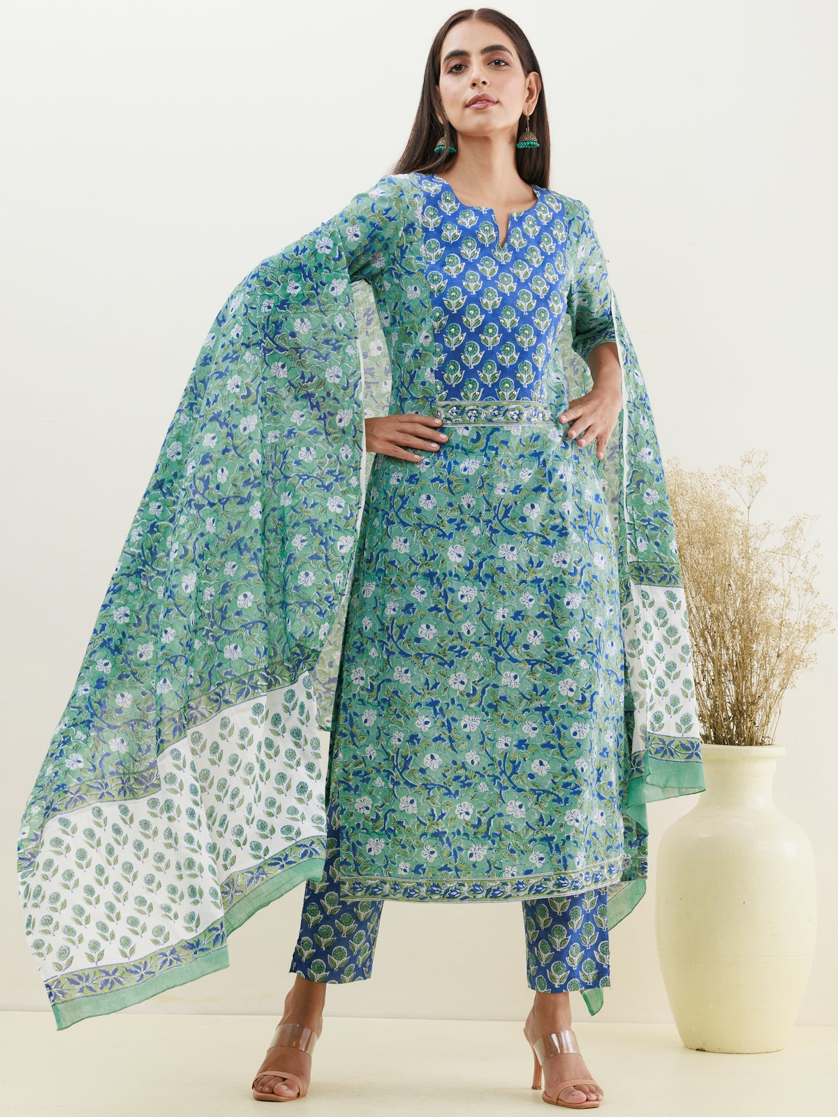 a woman wearing a green and blue printed dress