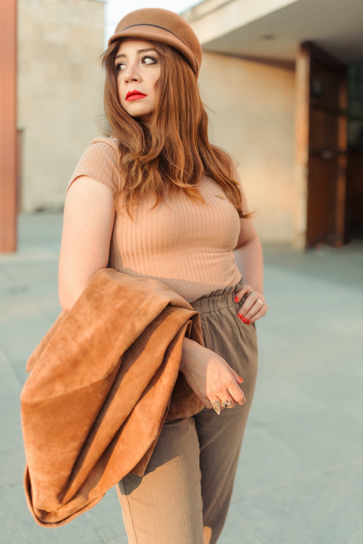 a woman in a tan top and brown pants