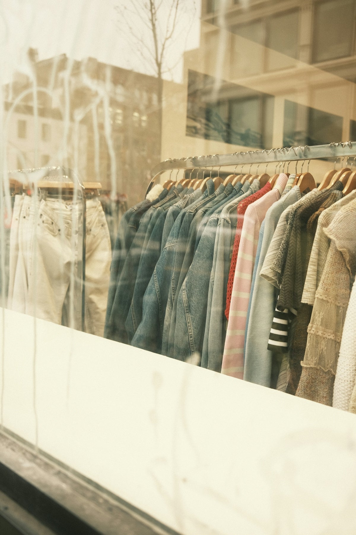 a bunch of shirts are hanging in a window