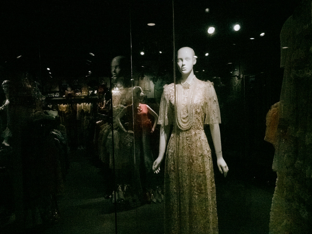 A mannequin is standing in front of a display of mannequins