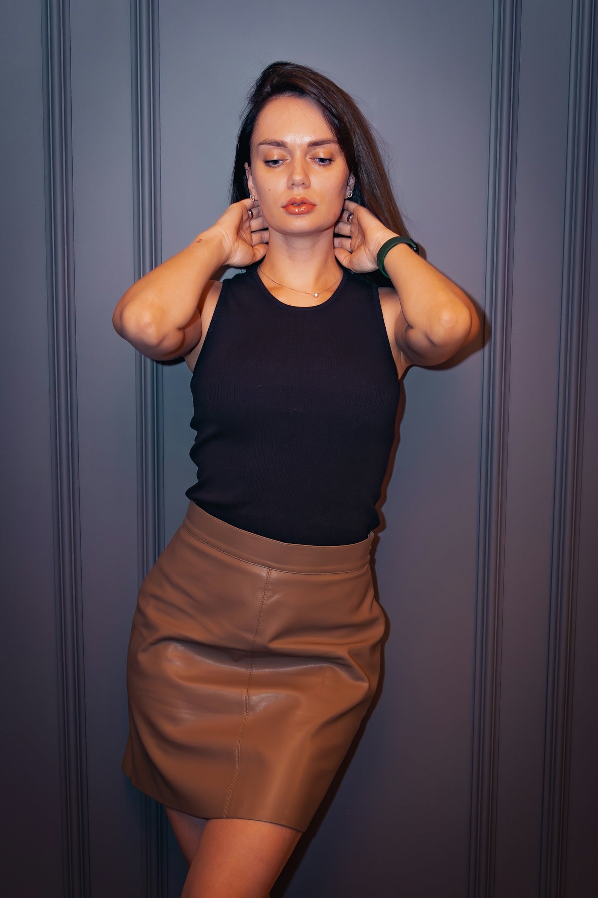 A woman in a black top and brown skirt