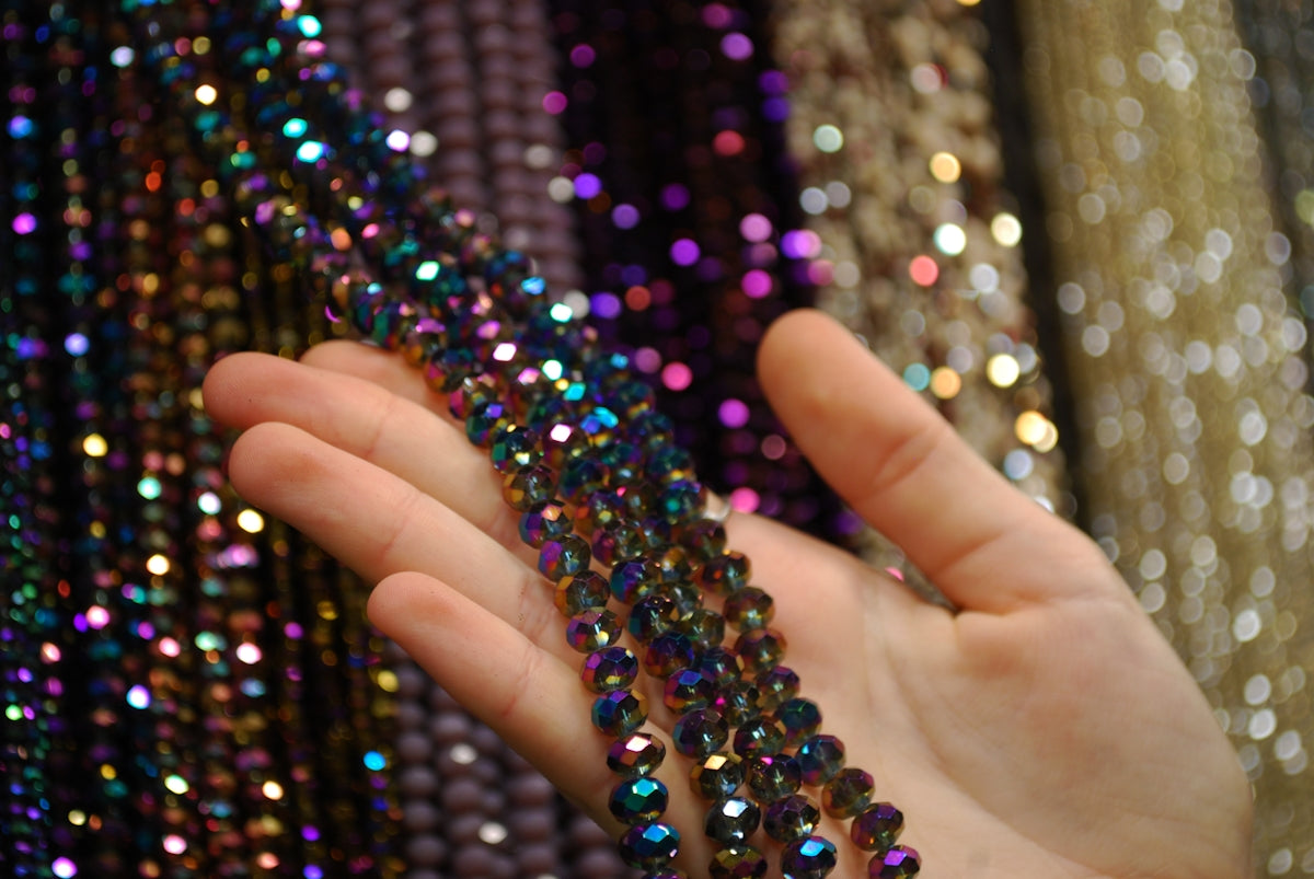 A hand is holding a string of beads