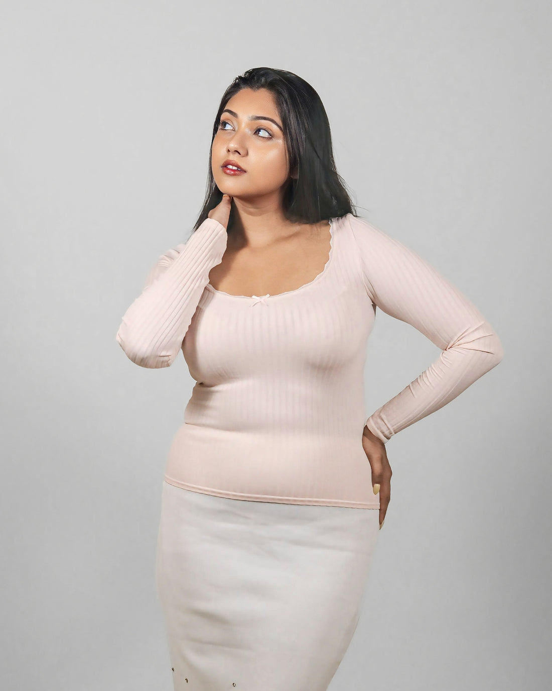 A woman posing for a picture in a skirt