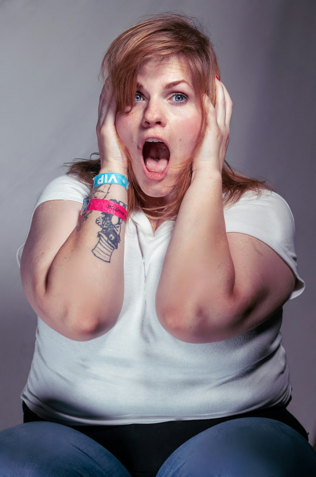 A woman sitting on the floor with her hands on her face
