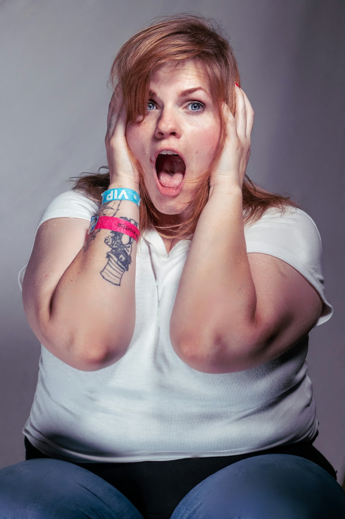 A woman sitting on the floor with her hands on her face
