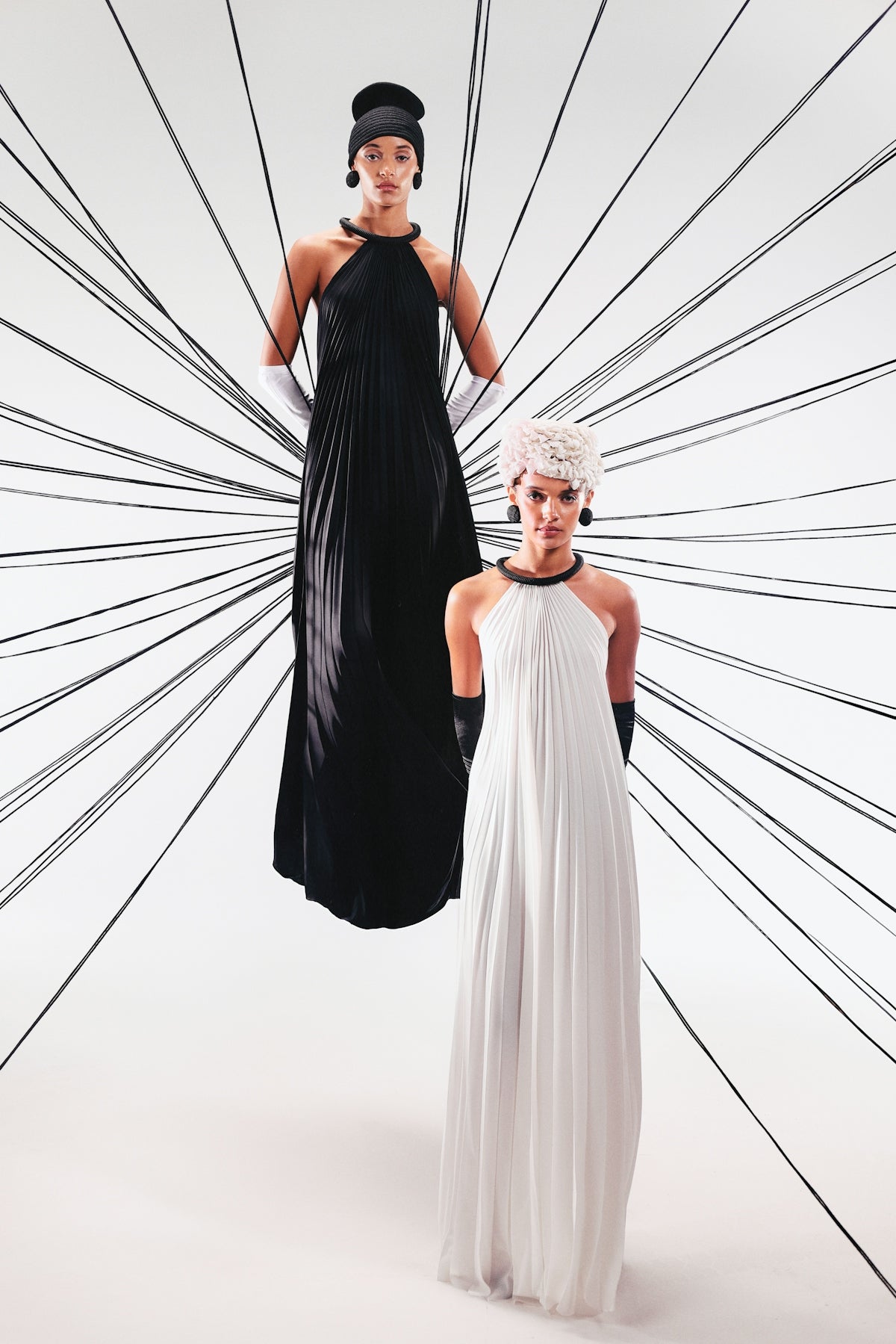 Models showcase dresses against a graphic background.