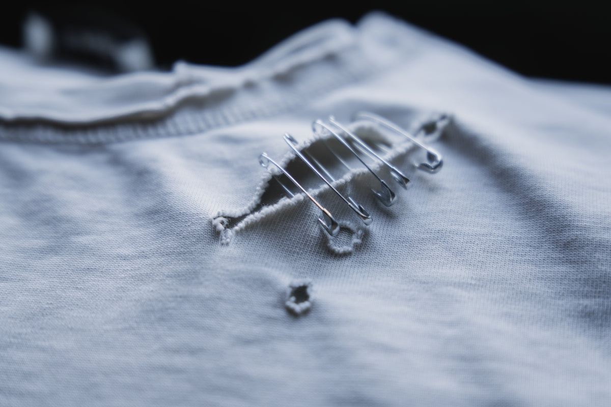 A t-shirt has been mended with safety pins.