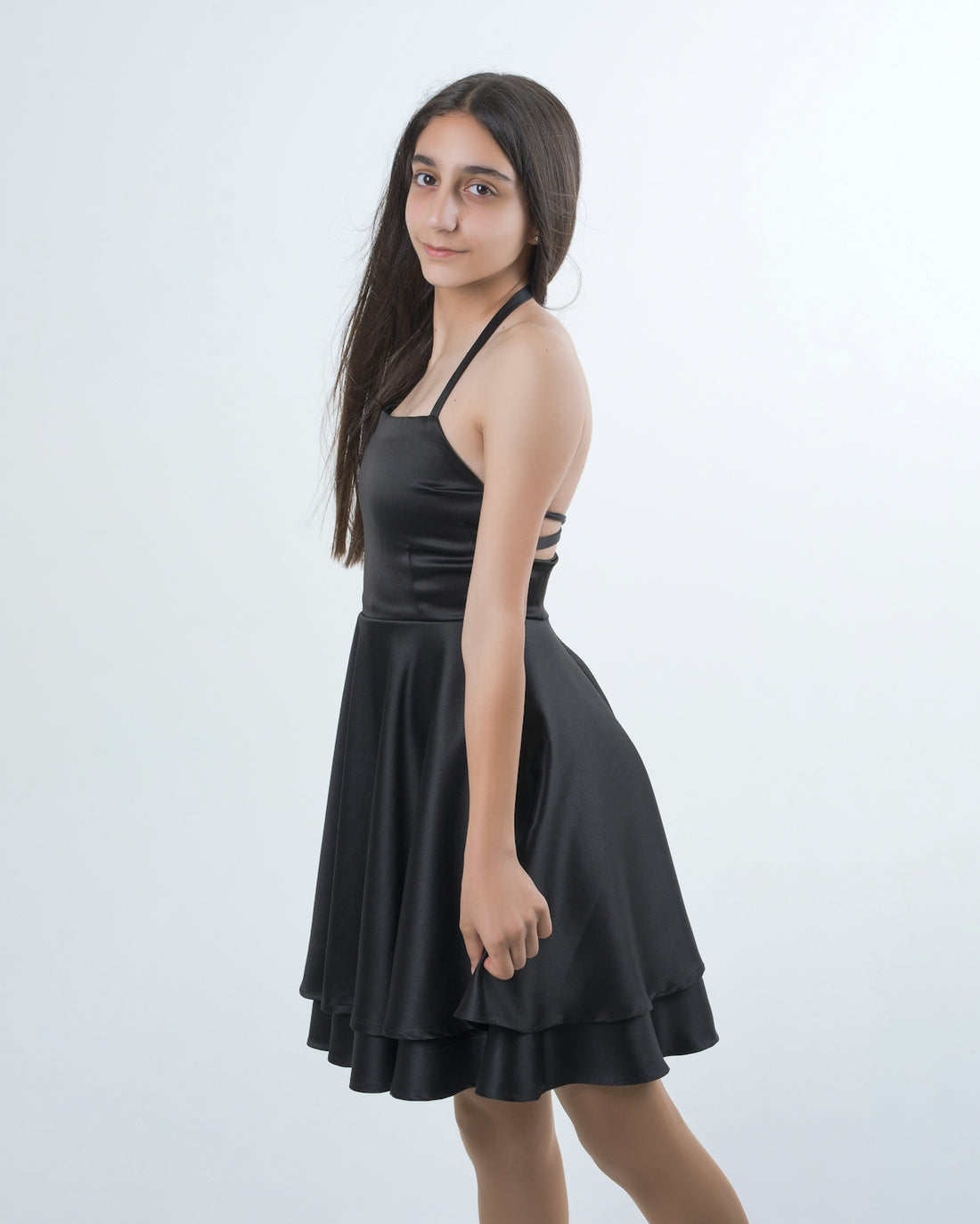 A young woman poses in a black dress.