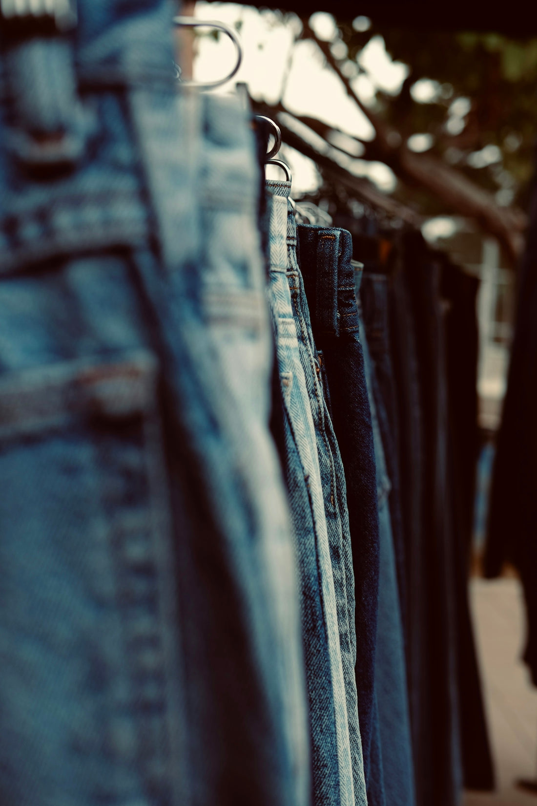 Jeans hang on a rack, waiting to be sold.