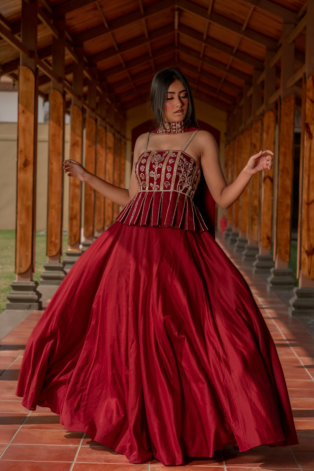 Woman in a red lehenga with ornate top.