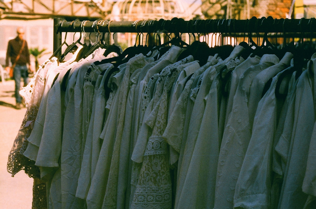 White clothing hanging on a rack outdoors.